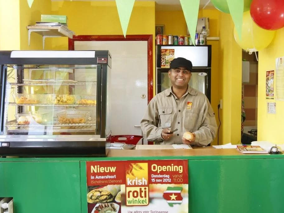 De toonbank van Krish Rotiwinkel met de warmhoudvitrine voor een gele muur.